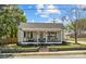 Inviting single-story home with a classic porch featuring a cozy seating area and beautiful landscaping at 207 Kerr Nw St, Concord, NC 28025