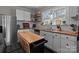 Bright kitchen features white cabinets, butcher block counters, stainless steel appliances and a movable island at 207 Kerr Nw St, Concord, NC 28025