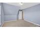 Bedroom with a window, plush carpet, and a door that leads to another area at 2125 Arbor Vista Dr, Charlotte, NC 28262