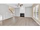 Open-concept living room with a cozy fireplace and hardwood floors at 2125 Arbor Vista Dr, Charlotte, NC 28262