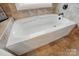 Close up of a modern tub and tile in a bright, renovated bathroom with great lighting at 307 Jaida Ln, Oakboro, NC 28129