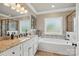Elegant bathroom featuring granite countertops, dual vanity, and a soaking tub under a frosted glass window at 307 Jaida Ln, Oakboro, NC 28129