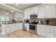 Well-lit kitchen featuring stainless steel appliances, white cabinets, and ample counter space at 307 Jaida Ln, Oakboro, NC 28129