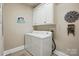 Bright laundry room featuring white washer and dryer, ample cabinet space, and decorative accents at 307 Jaida Ln, Oakboro, NC 28129