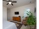 Bedroom with neutral walls and carpet, a TV, and a chair near a bright window at 314 Flat Rock Dr, Denver, NC 28037