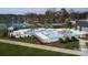 Aerial view of a community pool with modern design, tennis courts, and lush landscaping at 314 Flat Rock Dr, Denver, NC 28037
