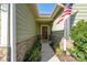 Inviting covered entryway featuring stone accents, manicured landscaping, and a dark wood front door at 314 Flat Rock Dr, Denver, NC 28037