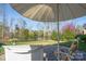 Inviting outdoor patio featuring comfortable lounge chairs, an umbrella, and a serene view of the backyard at 314 Flat Rock Dr, Denver, NC 28037