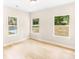 Bright bedroom featuring three windows offering natural light, complemented by hardwood flooring for a clean, modern aesthetic at 315 Club House Dr, Salisbury, NC 28144