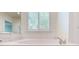 Bathroom featuring a white drop-in tub with shuttered window at 320 Falesco Ln, Matthews, NC 28105