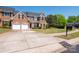 Beautiful brick home with a two-car garage, manicured lawn, and mature trees at 320 Falesco Ln, Matthews, NC 28105