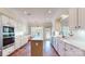 Open kitchen featuring stainless steel appliances, white cabinetry, and terra cotta flooring with a center island at 320 Falesco Ln, Matthews, NC 28105