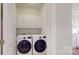 Bright laundry room featuring a pair of white, front-loading washers and dryers at 320 Falesco Ln, Matthews, NC 28105