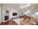 Open-concept living room with a fireplace, hardwood flooring, and a large leather sectional sofa at 320 Falesco Ln, Matthews, NC 28105
