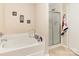 Bright bathroom featuring a soaking tub, a separate shower, and neutral tile flooring at 3254 Pikes Peak Dr, Gastonia, NC 28052