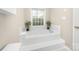 Relaxing tub in a spa-like bathroom with tiled platform and bright window at 3866 Bethany Nw Ct, Concord, NC 28027