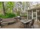 Outdoor deck with grill and seating surrounded by lush greenery and mature trees at 3866 Bethany Nw Ct, Concord, NC 28027
