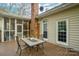 Outdoor deck with seating and table, attached to a screened-in patio space at 3866 Bethany Nw Ct, Concord, NC 28027