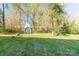 This is a backyard with trees and green grass and a shed for storage at 3921 Bon Rea Dr, Charlotte, NC 28226