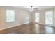 This spacious bedroom features three windows, a ceiling fan, and sleek, modern, laminate flooring at 3921 Bon Rea Dr, Charlotte, NC 28226