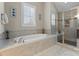Bathroom with large soaking tub, glass shower enclosure and window with wooden shutters at 400 Eden Hollow Ln, Weddington, NC 28104