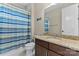 Bathroom with dark cabinets, granite counters and shower with light-colored blue, green and white striped curtain at 400 Eden Hollow Ln, Weddington, NC 28104