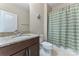 Bathroom with neutral colors, dark cabinets, granite counters and shower with green and white curtain at 400 Eden Hollow Ln, Weddington, NC 28104