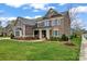 Beautiful two-story house with a manicured lawn and a welcoming entrance with stone and shingle accents at 400 Eden Hollow Ln, Weddington, NC 28104