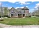 Charming two-story home featuring a beautifully landscaped yard with a mix of stone and shingle siding at 400 Eden Hollow Ln, Weddington, NC 28104