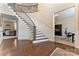 Grand foyer featuring a curved staircase, hardwood floors, and detailed wainscoting at 400 Eden Hollow Ln, Weddington, NC 28104
