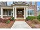Inviting front porch with stone steps, white pillars, and a decorative double front door entrance at 400 Eden Hollow Ln, Weddington, NC 28104