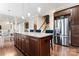 Open kitchen with a granite island, stainless steel fridge, and seamless access to the dining area at 400 Eden Hollow Ln, Weddington, NC 28104