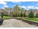 Beautiful backyard patio features stone pavers, a stone wall, and lush landscaping, perfect for outdoor living at 400 Eden Hollow Ln, Weddington, NC 28104