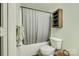 Compact bathroom with mint walls features tub with shower, toilet and vintage inspired storage cabinet at 413 Lexie Ln # 92, Rock Hill, SC 29732