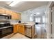 Open-concept kitchen seamlessly flows into living room, stainless steel appliances and wood cabinets enhance this functional space at 413 Lexie Ln # 92, Rock Hill, SC 29732
