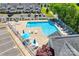 Bright community pool surrounded by lounge chairs, umbrellas, and a white picket fence at 413 Lexie Ln # 92, Rock Hill, SC 29732