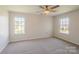 Spacious bedroom with carpet, two windows for natural light, and a ceiling fan at 4200 Long Arrow Dr, Concord, NC 28025