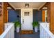 Stylish front porch with a welcome mat, potted plants, and wooden accents on the doorframe at 4429 Major St, Charlotte, NC 28208