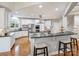 Large, bright kitchen with white cabinets, stainless steel appliances, and a breakfast bar at 516 White Tail Ter, Waxhaw, NC 28173