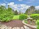 This tranquil backyard features lush landscaping and a charming fountain enhancing the property's appeal and serenity at 516 White Tail Ter, Waxhaw, NC 28173