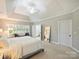 Serene main bedroom featuring tray ceilings, carpet, and a doorway to a private ensuite bathroom at 516 White Tail Ter, Waxhaw, NC 28173