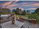 Outdoor kitchen on a wooden deck features a grill, pizza oven, and a dining table at 516 White Tail Ter, Waxhaw, NC 28173