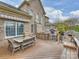 A wooden deck features an outdoor kitchen with a pizza oven, built-in grill, dining table, and views of the brick home at 516 White Tail Ter, Waxhaw, NC 28173