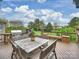 A wooden deck features an outdoor kitchen with a pizza oven, built-in grill, and a dining table overlooking the lawn at 516 White Tail Ter, Waxhaw, NC 28173