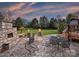 Stone patio features outdoor seating, a fireplace, and a view of the landscaped backyard at 516 White Tail Ter, Waxhaw, NC 28173