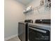 Modern laundry room boasting stainless steel washer and dryer, storage shelves, and tiled floors for convenience at 533 Cedar Knoll Cir, Pineville, NC 28134