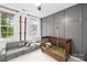 Cozy bedroom with a gray accent wall, a crib, and comfortable seating at 5549 Lemley Nw Rd, Concord, NC 28027