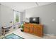 Bright, neutral bedroom showing a wooden dresser, decorative toys, and a window with natural light at 5549 Lemley Nw Rd, Concord, NC 28027