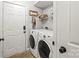 Clean laundry area with washer, dryer, and white door, complete with shelving and stylish decorations at 5549 Lemley Nw Rd, Concord, NC 28027