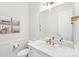 Well-lit bathroom featuring an undermount sink, brushed gold fixtures, and wainscotting at 6006 Waxhaw Crossing Dr, Waxhaw, NC 28173